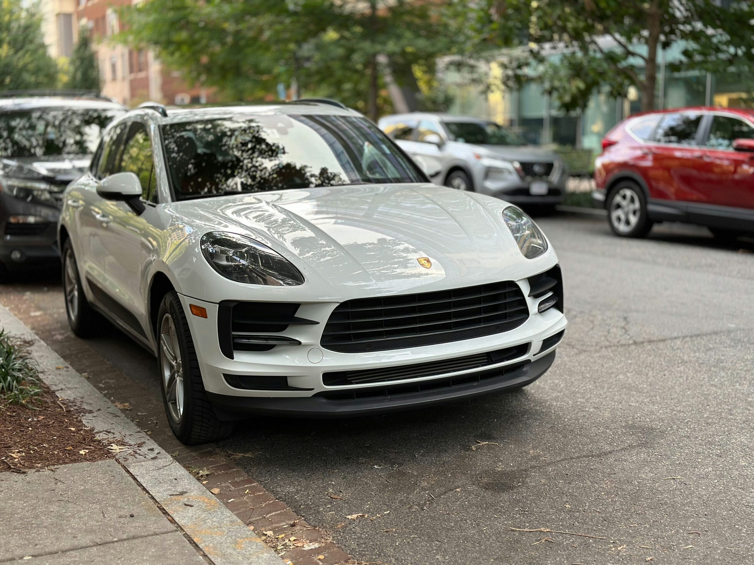 通りの脇に白いポルシェカイエンが停まっています